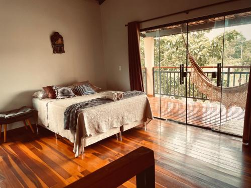 una camera da letto con un letto e una grande finestra di Claruá Chalés - Loft Caju - Romântico & Charmoso em Cavalcante Chap dos Veadeiros a Cavalcante