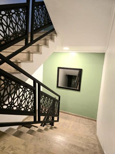 a staircase with a television on a green wall at AS Premium By Soho Hotels Maarif in Casablanca