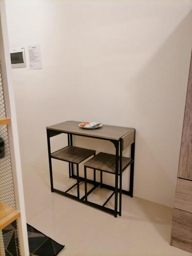 a small black table with two chairs in a room at Modena Town Square - BM Rentals in Minglanilla