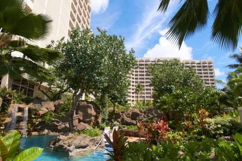 a resort with a waterfall and trees and buildings at Hyatt Regency Guam in Tumon