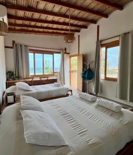 two beds in a room with windows at Casa Pacifico in Los Órganos