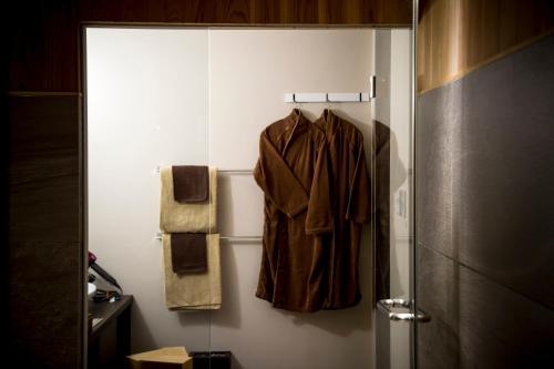 a robe hanging on a wall in a bathroom at HOSHINO-OTOー星音 in Miyazu