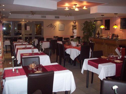a restaurant with tables with red and white tablecloths at Kimotel Epône-Flins in Épône