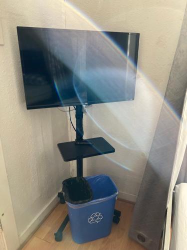 a flat screen tv sitting on a stand next to a bucket at Quesada Homestay in San Francisco