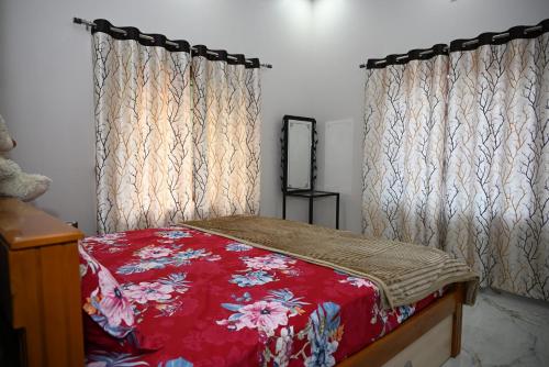 a bedroom with a red bed with curtains at Barnes homestay in Kalyānpur