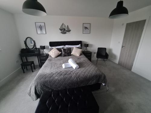 a bedroom with a bed with two towels on it at SAV Stays 5 Bed Luxury Detached House in Leicester in Humberstone