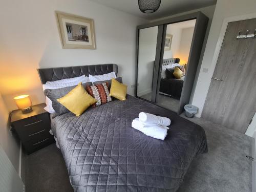 a bedroom with a large bed with towels on it at SAV Stays 5 Bed Luxury Detached House in Leicester in Humberstone