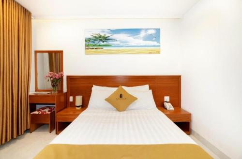 a bedroom with a large bed with white sheets at Mira Eco Hotel Quy Nhon in Quy Nhon