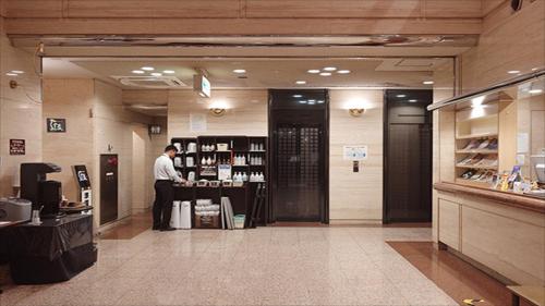 a man standing at a counter in a store at Hotel Crown Hills Kanazawa in Kanazawa