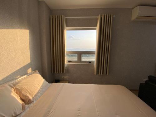 a bedroom with a bed and a window with a view at Juna hotel in Thanh Hóa
