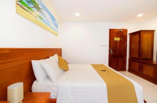 a bedroom with a large bed with a wooden headboard at Mira Eco Hotel Quy Nhon in Quy Nhon