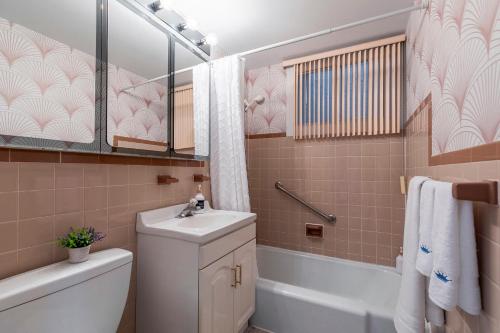 a bathroom with a sink and a toilet and a tub at Cozy Montreal Entire Apartment-3min walk to Metro-free parking-Botanical garden-biodome in Montréal
