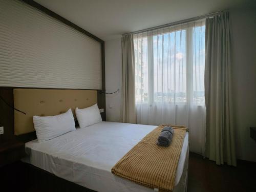 a bedroom with a bed and a large window at BCC Hotel & Residence Apartment in Bagam