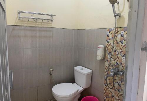 a bathroom with a toilet and a shower curtain at Art Guest House Syariah by Secoms in Timuran