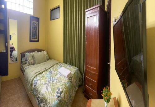 a small bedroom with a bed and a closet at Art Guest House Syariah by Secoms in Timuran