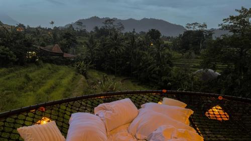 a bunch of pillows sitting on top of a balcony at Nivriti Bali in Sidemen