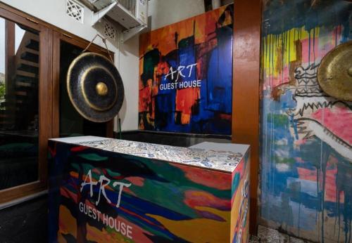 a colorful box sitting next to a wall with paintings at Art Guest House Syariah by Secoms in Timuran