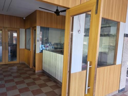 an empty room with wooden walls and glass doors at Alohi Homestay Near Rahman Hospitals Pvt Ltd in Guwahati