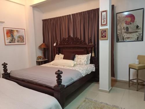 Un dormitorio con una cama con cabecero de madera. en Villa Medina 12 pax private bungalow at Pantai Bagan Lalang, en Tanjong Sepat