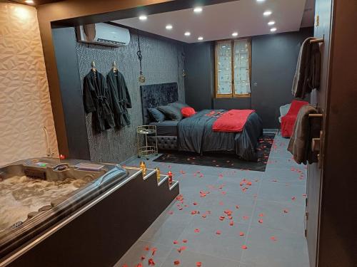 a bedroom with a bed with red flowers on the floor at Sweety's Eden Jacuzzi - Spa privé Sauna Cinéma room Jardin - Terrasse centre-ville in Le Mans