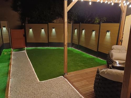 a patio with green grass and a gazebo at Sweety's Eden Jacuzzi - Spa privé Sauna Cinéma room Jardin - Terrasse centre-ville in Le Mans