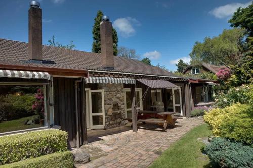 a house with a brick patio in front of it at Mountain Bike Manor in Rotorua