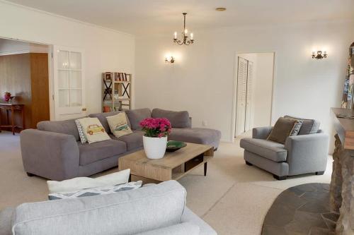 a living room with two couches and a table at Mountain Bike Manor in Rotorua