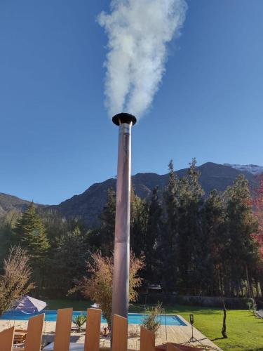 a tall smoke stack with smoke coming out of it at Parcela Santa Elena, Cabaña 2 in San José de Maipo