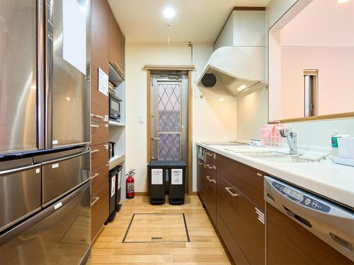 a large kitchen with a sink and a refrigerator at 上野Nipporiテラスー寛道ー in Tokyo