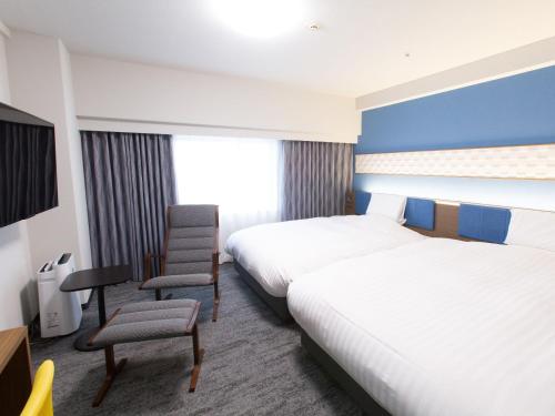 Postel nebo postele na pokoji v ubytování Toyama Chitetsu Hotel