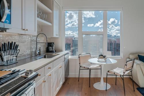 a white kitchen with a table and a window at Top floor Deluxe 1BR Pool,Gym,Htub,Bowling and More in Salt Lake City