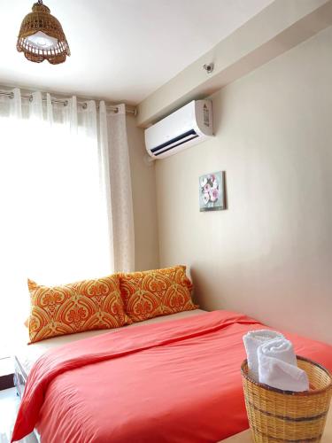 a bedroom with a red bed and a window at The Ecru Suite in Lapu Lapu City