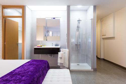 1 dormitorio con ducha, 1 cama y lavamanos en Suites Garden Loft El Greco, en Las Palmas de Gran Canaria