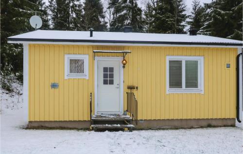a yellow house with a white door in the snow at 1 Bedroom Stunning Home In Fegen in Fegen