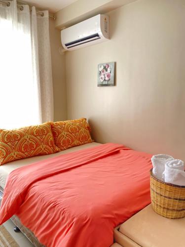 a bedroom with a red bed and a window at The Ecru Suite in Lapu Lapu City