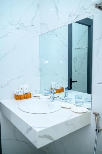 a white bathroom with a sink and a mirror at 6668 Hotel - Chi nhánh 1 in Tây Ninh