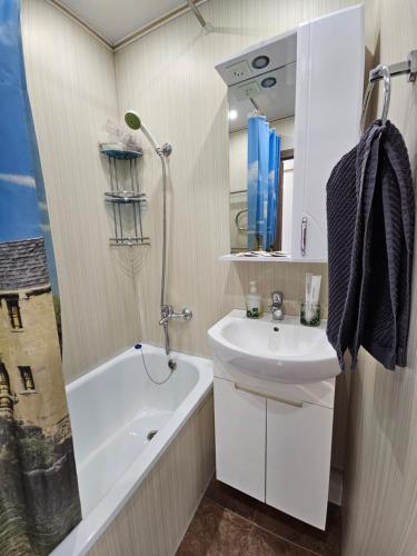 a bathroom with a sink and a bath tub and a sink at Lux Apartment on Mayakovsky 6 in Ustʼ-Kamenogorsk