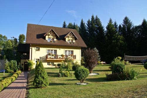 ein Haus mit einem braunen Dach im Hof in der Unterkunft Agroturystyka Leśny Zakątek in Stryszawa