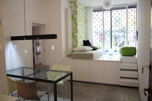 sala de estar con mesa de cristal y ventana en Apartment Quattro, en Milán