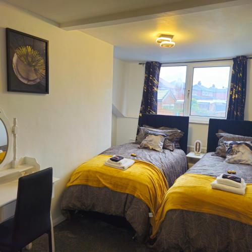 a bedroom with two beds and a window at West park Royal House, Holidays, Contractors,Relocation,Free Parking & WiFi in Preston