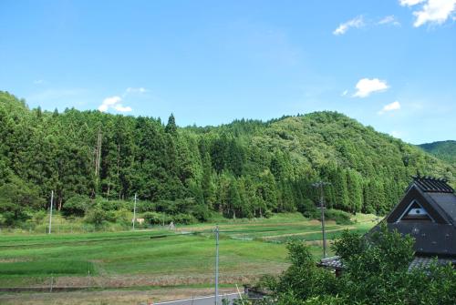 a cabin in the middle of a field with a mountain at AZAE Kyoto Japan in Shūzan