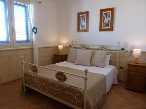 LendinusoにあるVilla Azzurraのベッドルーム1室(白いベッド1台、窓2つ付)