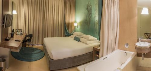 a hotel room with a bed and a bath tub at Metcourt at Emperors Palace in Kempton Park