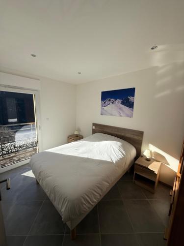une chambre avec un grand lit et une fenêtre dans l'établissement Appartement Orelle/Val Thorens, à Orelle
