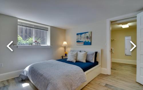 a bedroom with a bed with a blue blanket and a window at Cozy Portland Retreat in the Heart of Hollywood in Portland
