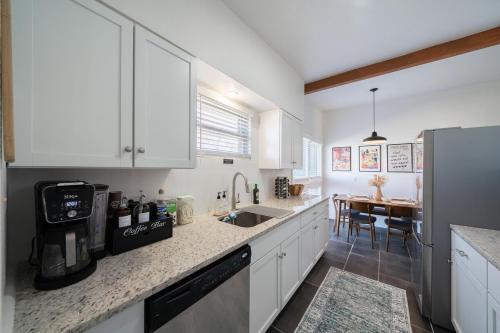 a kitchen with white cabinets and a dining table at Charming,comfy home near San Antonio's top sights in San Antonio