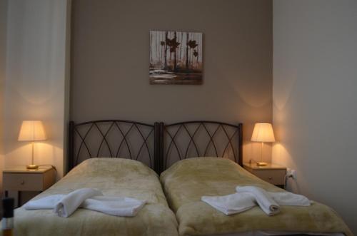 un letto con due asciugamani sopra con due lampade di Archontissa a Ermoupoli