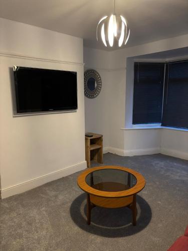 a living room with a coffee table and a flat screen tv at cozy two bedroom home in Hull