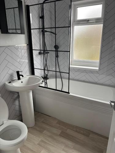 a bathroom with a sink and a toilet and a window at cozy two bedroom home in Hull