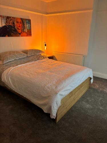 a bedroom with a large bed with an orange wall at cozy two bedroom home in Hull